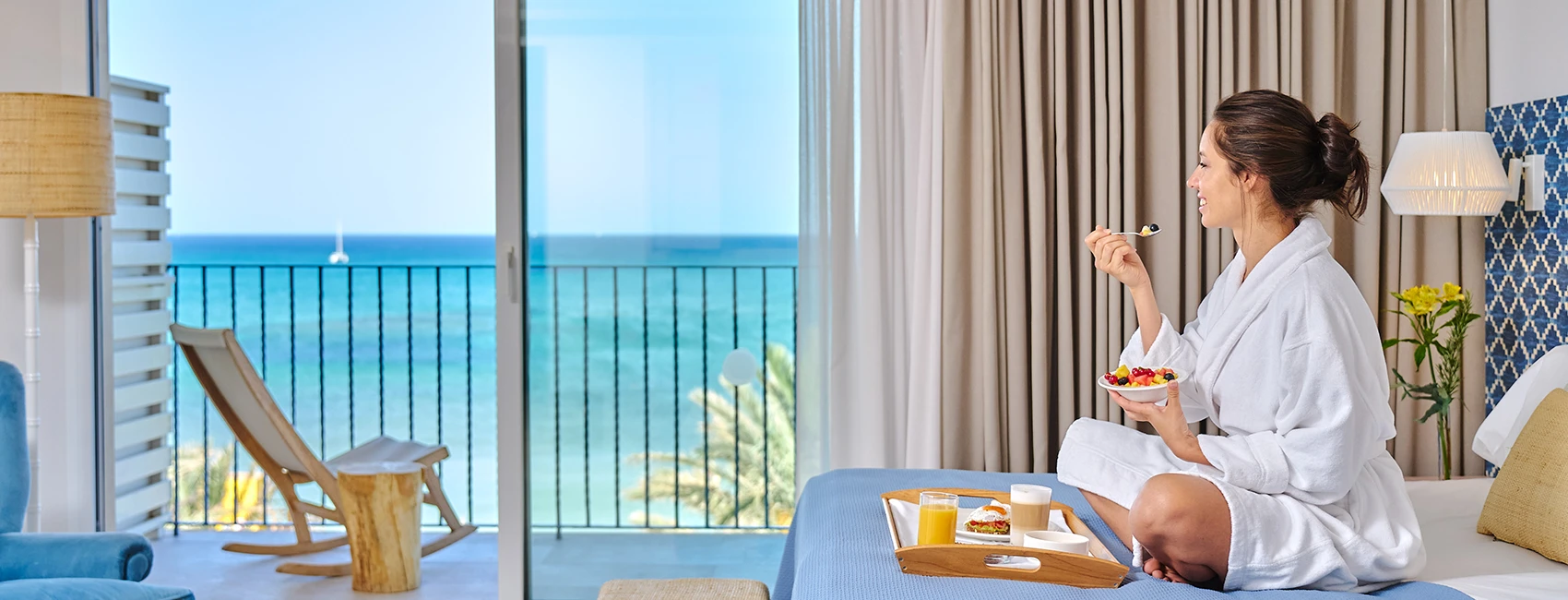 Frau frühstückt im Bett mit Meerblick Zimmer im Hotel MYSEAHOUSE Flamingo
