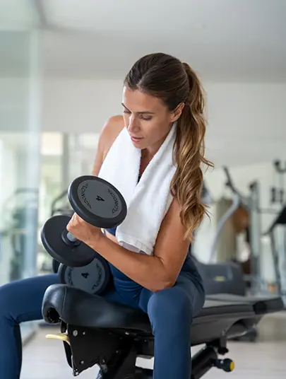 Servicios Gimnasio Hotel MYSEAHOUSE Flamingo Mujer haciendo pesas en el Gimnasio Hotel MYSEAHOUSE Flamingo
